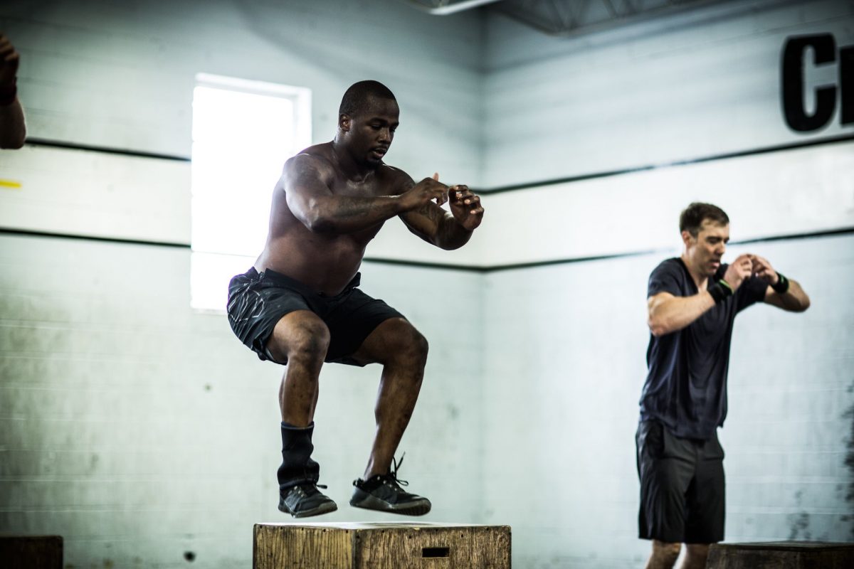 a pair of men doing box jumps