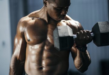 Men doing biceps curl in gym.