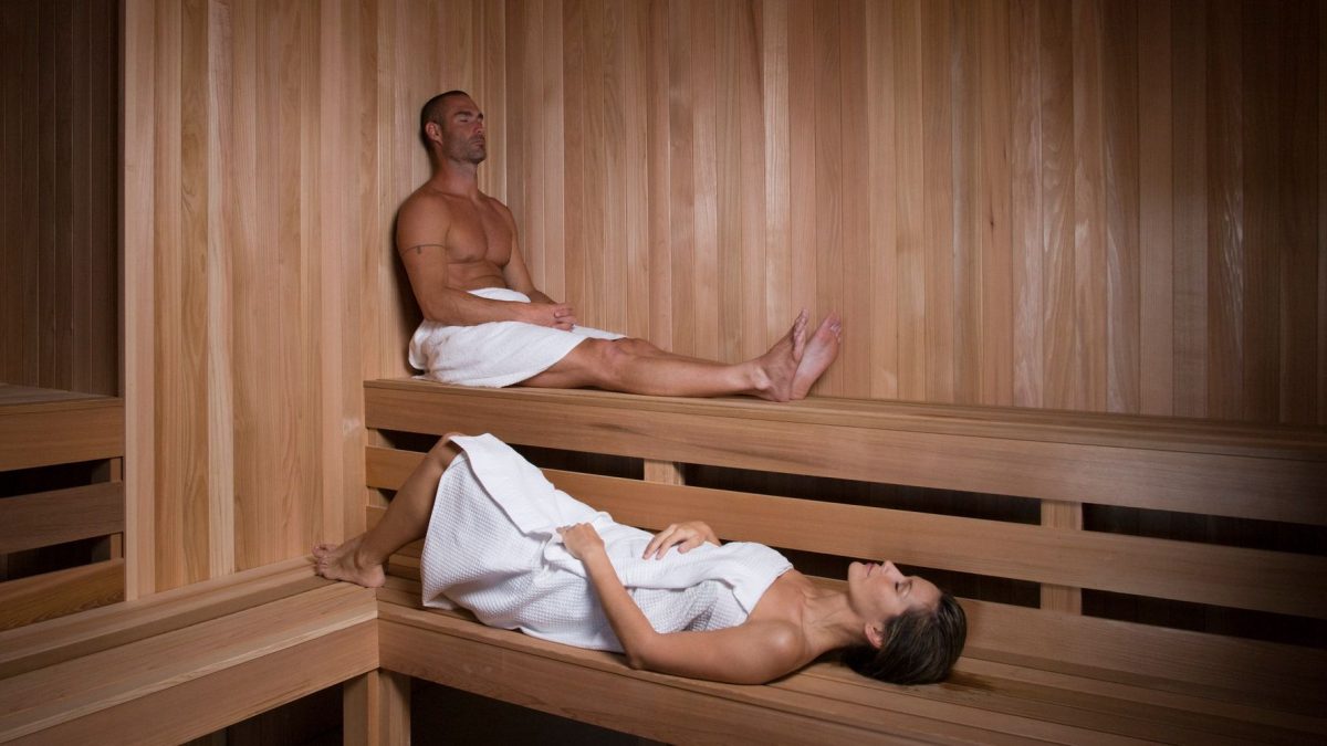 a couple relaxing in a cedar lined sauna