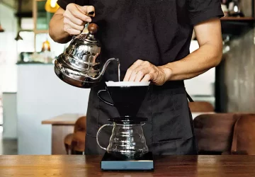 a person brewing coffee