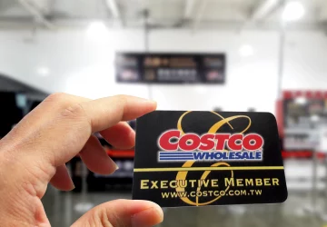 a person holding up their costco membership card