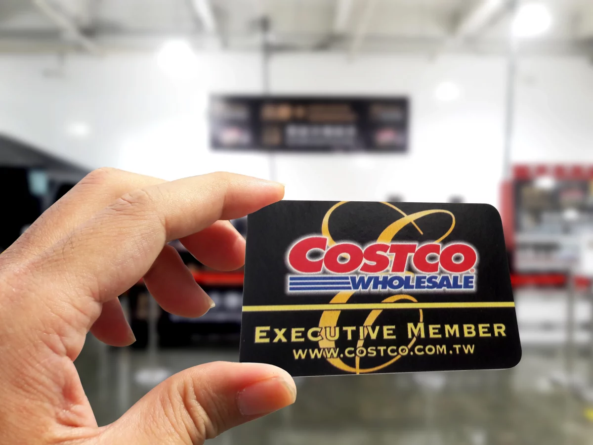 a person holding up their costco membership card
