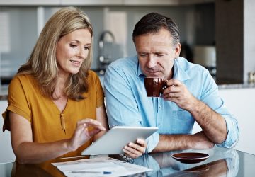 Shot of a mature couple paying their bills online from home