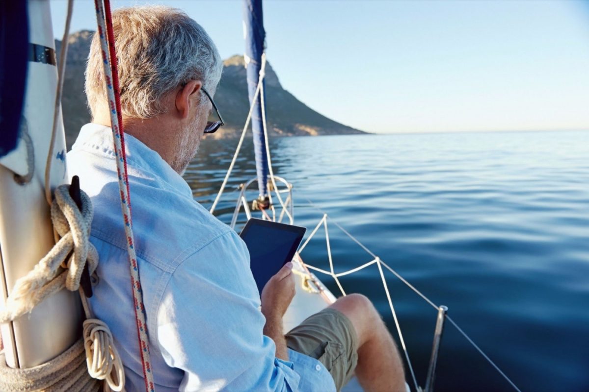 a man on a boat reading news from his tablet