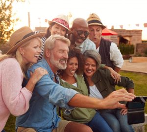a group of adults posing for a selfie outdoors
