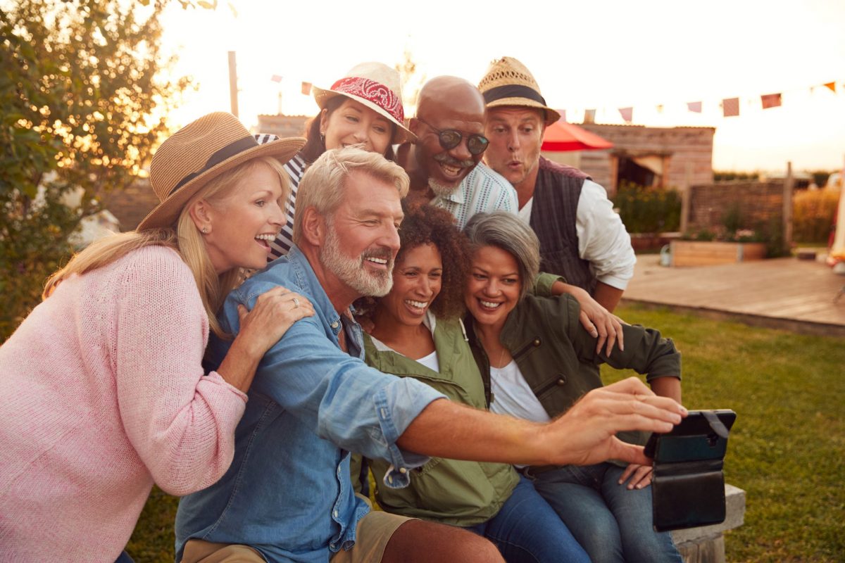 a group of adults posing for a selfie outdoors