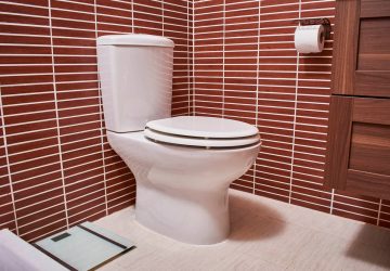 a toilet in a brown tiled room